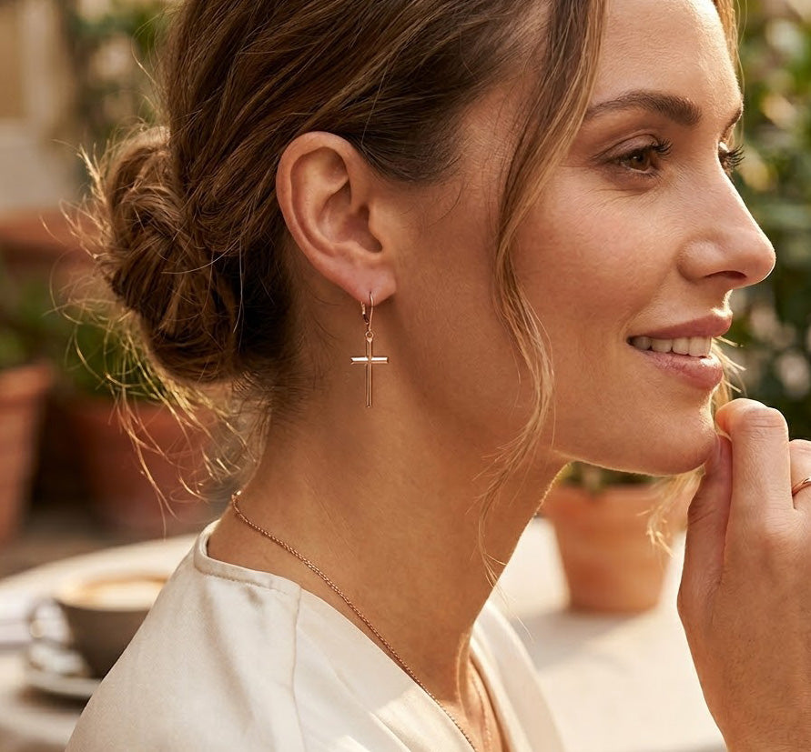 model wearing gold cross earring