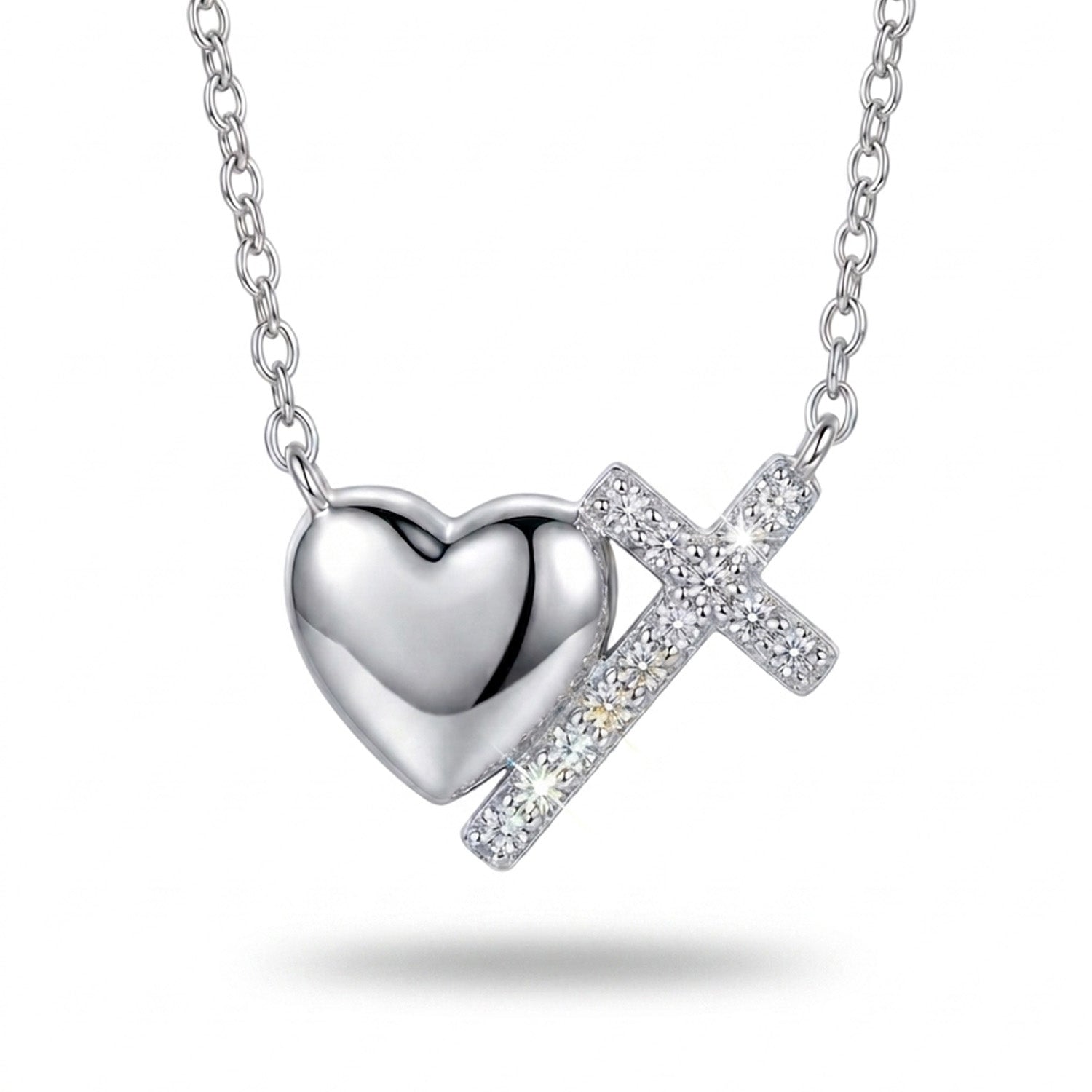 Silver heart and cross pendant necklace on a white background