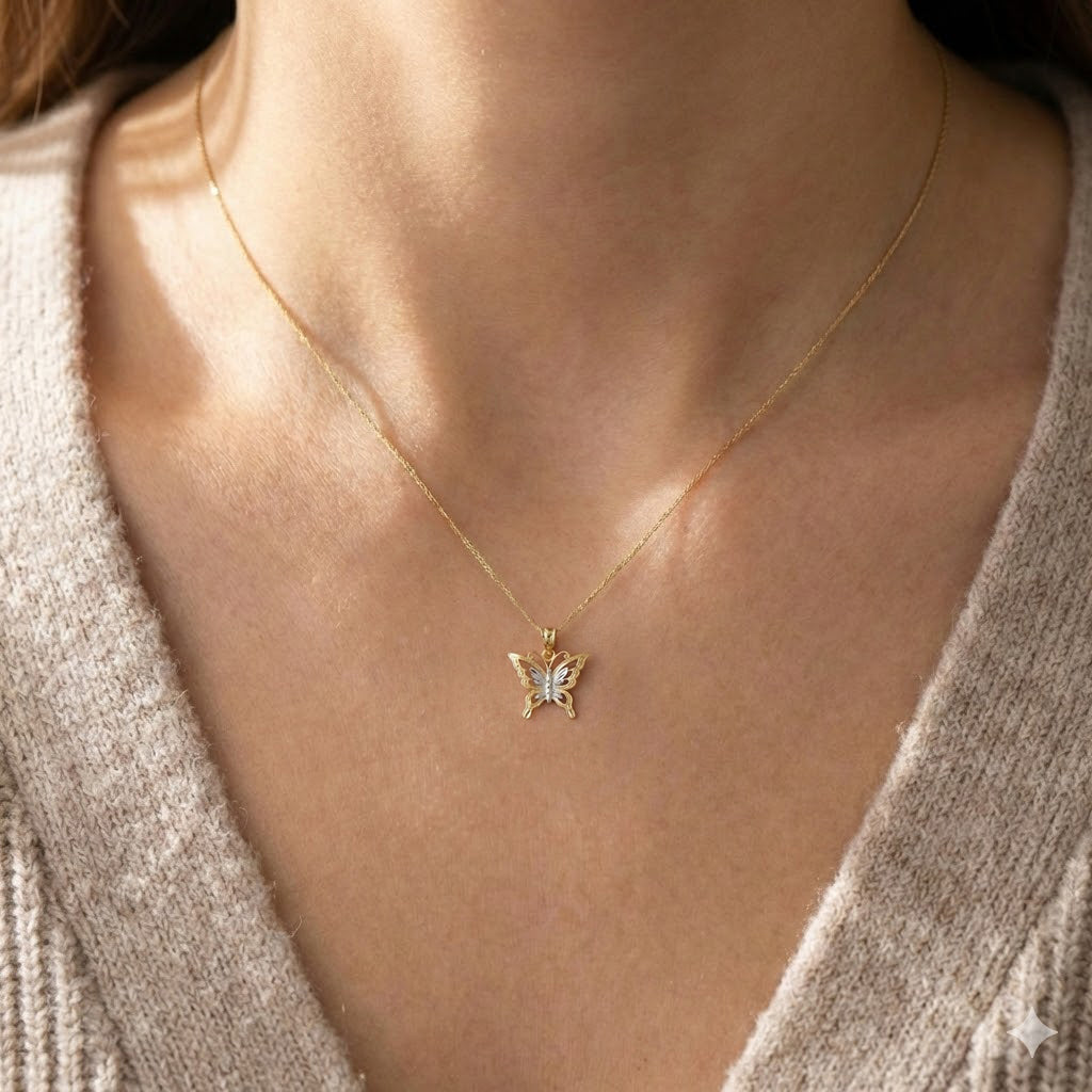 Gold necklace with a butterfly pendant worn by a person