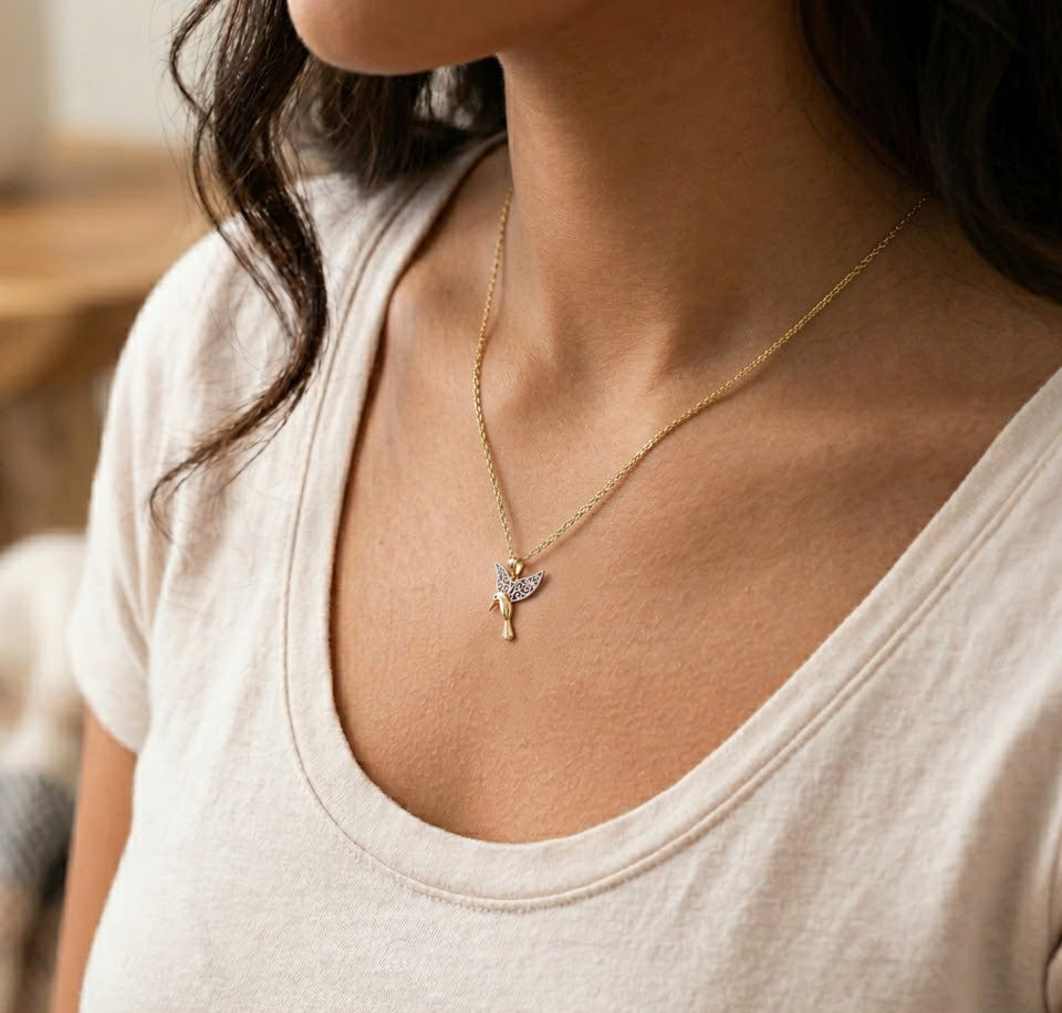 model wearing gold hummingbird pendant on gold chain