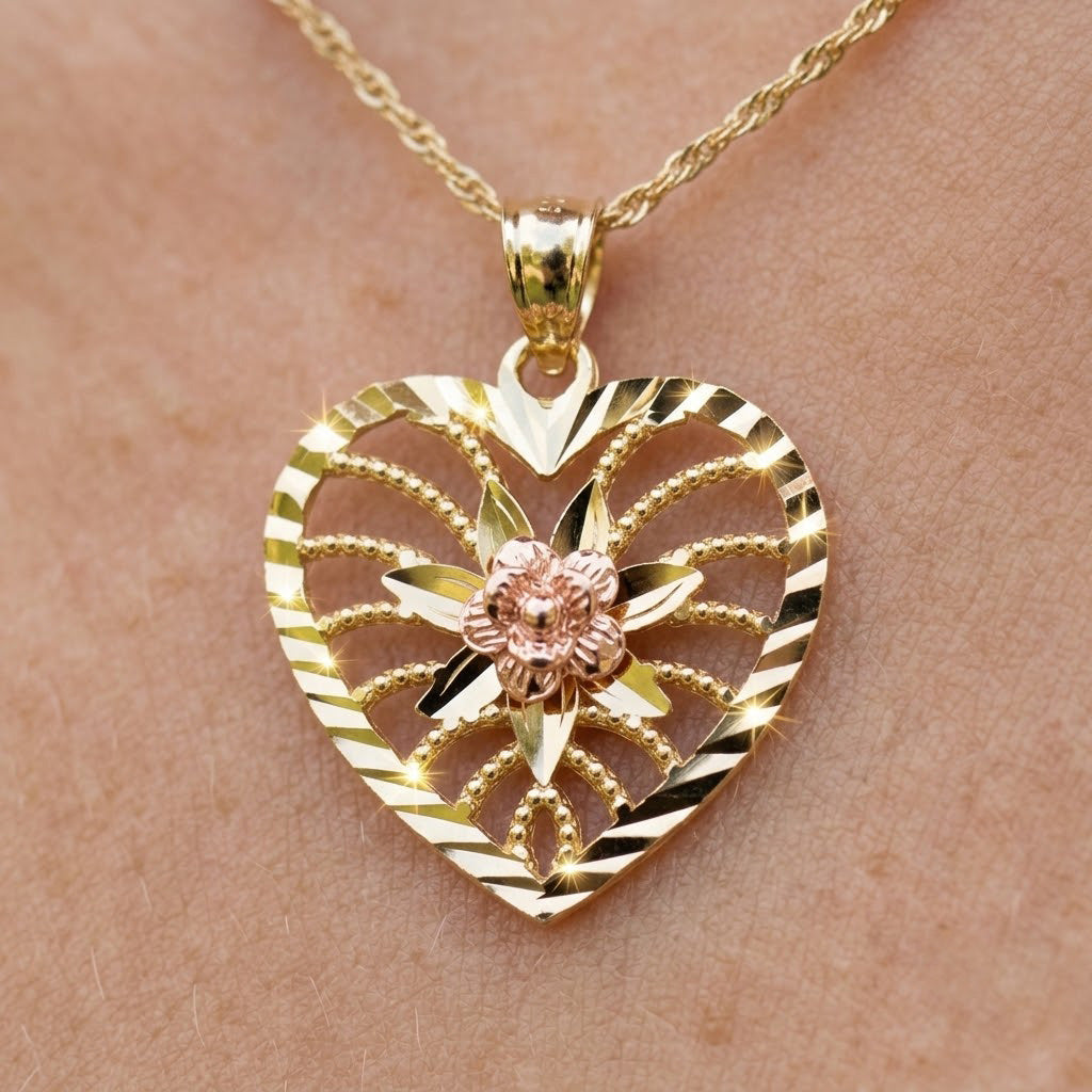 Gold heart-shaped pendant with floral design on a chain against a skin background