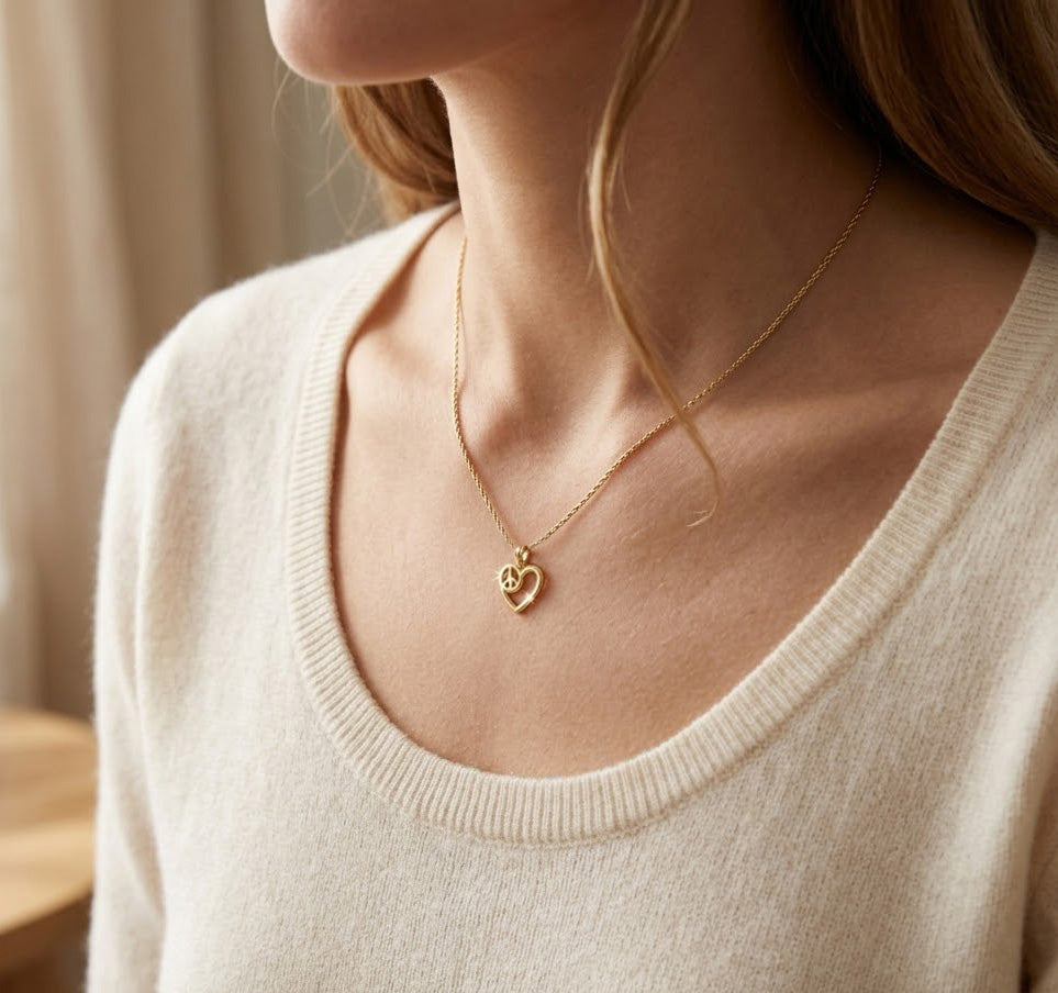 gold heart with peace sign pendant on female model
