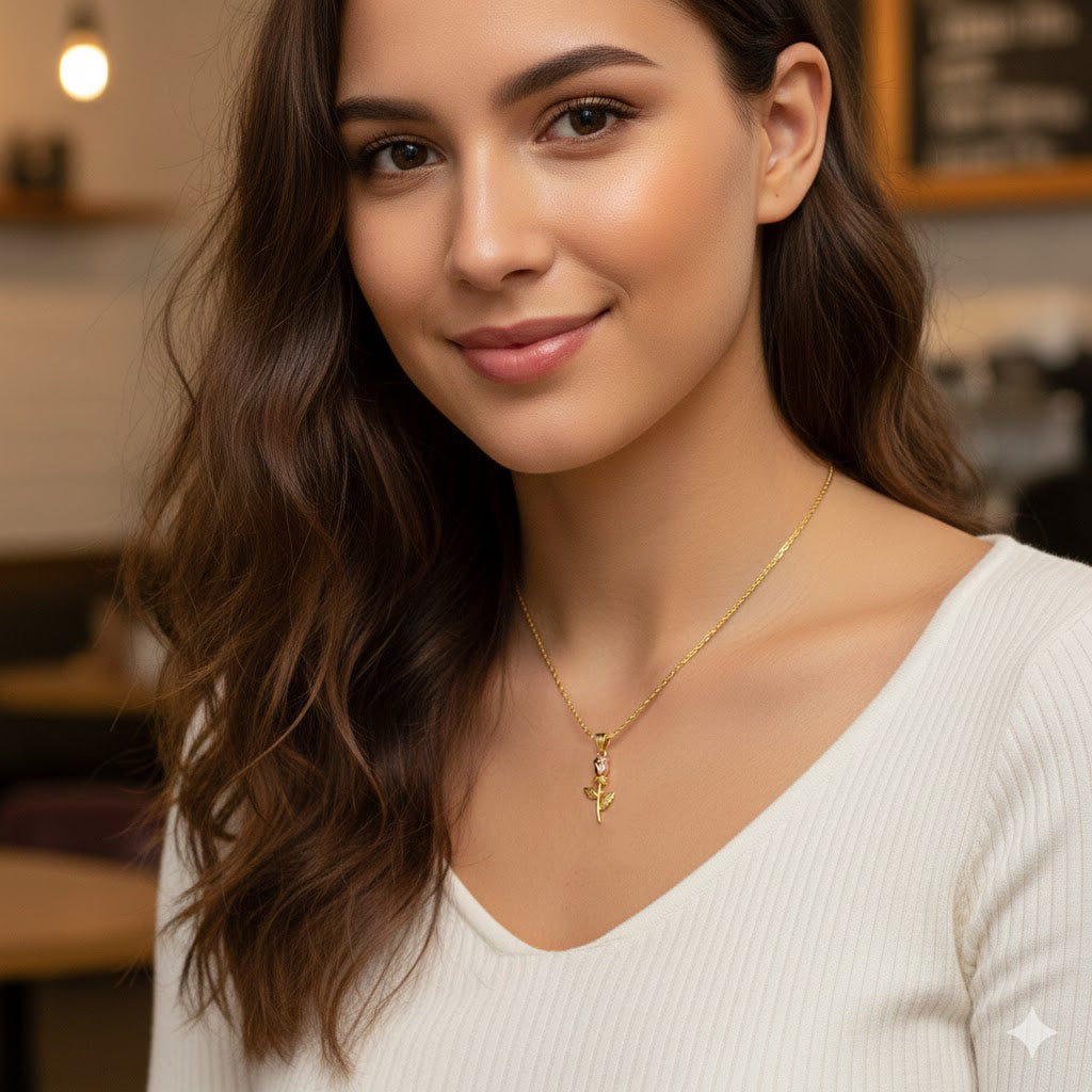 Woman wearing a gold necklace with a pendant in an indoor setting