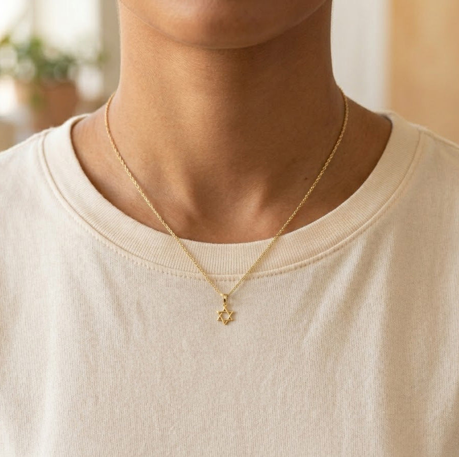 Gold star of david pendant on gold rope chain worn by female model