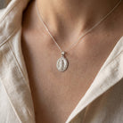 Silver Lady of Guadalupe Necklace
  on a person wearing a beige shirt.