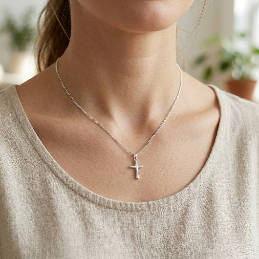 silver cross necklace worn by female model 