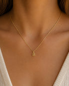 [group: b-10k-gold]A delicate gold chain necklace with a small letter 'B' initial pendant, shown worn on a model's neck.