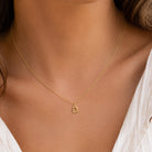 [group:d-10k-gold]A delicate gold chain necklace with a small letter 'D' initial pendant, shown worn on a model's neck.