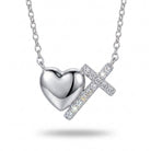 Silver heart and cross pendant necklace on a white background