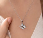 Silver necklace with 'LOVE' pendant on a person's neck