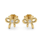 A pair of gold bow stud earrings with a single round-cut clear diamond at the center of each bow, shown on a plain white background.
