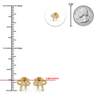 Gold bow-shaped stud earrings with clear rhinestones, shown with measurement markings, a circular inset of a single earring back, and a 25 mm coin for scale on a white background.