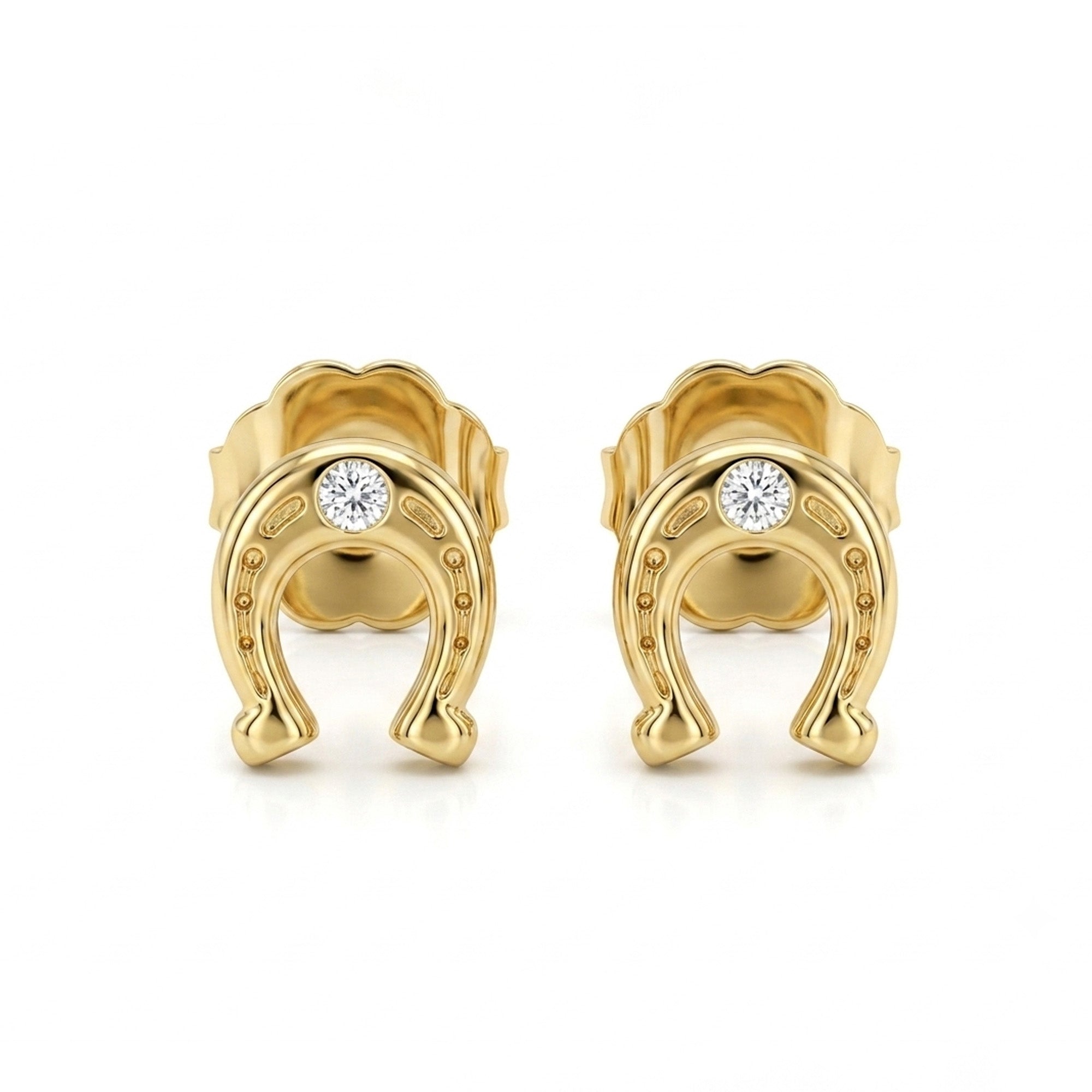 A pair of gold horseshoe stud earrings, each featuring a small round clear gemstone set in the center, displayed on a clean white background.