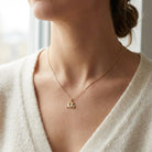 gold cat pendant worn by female model 