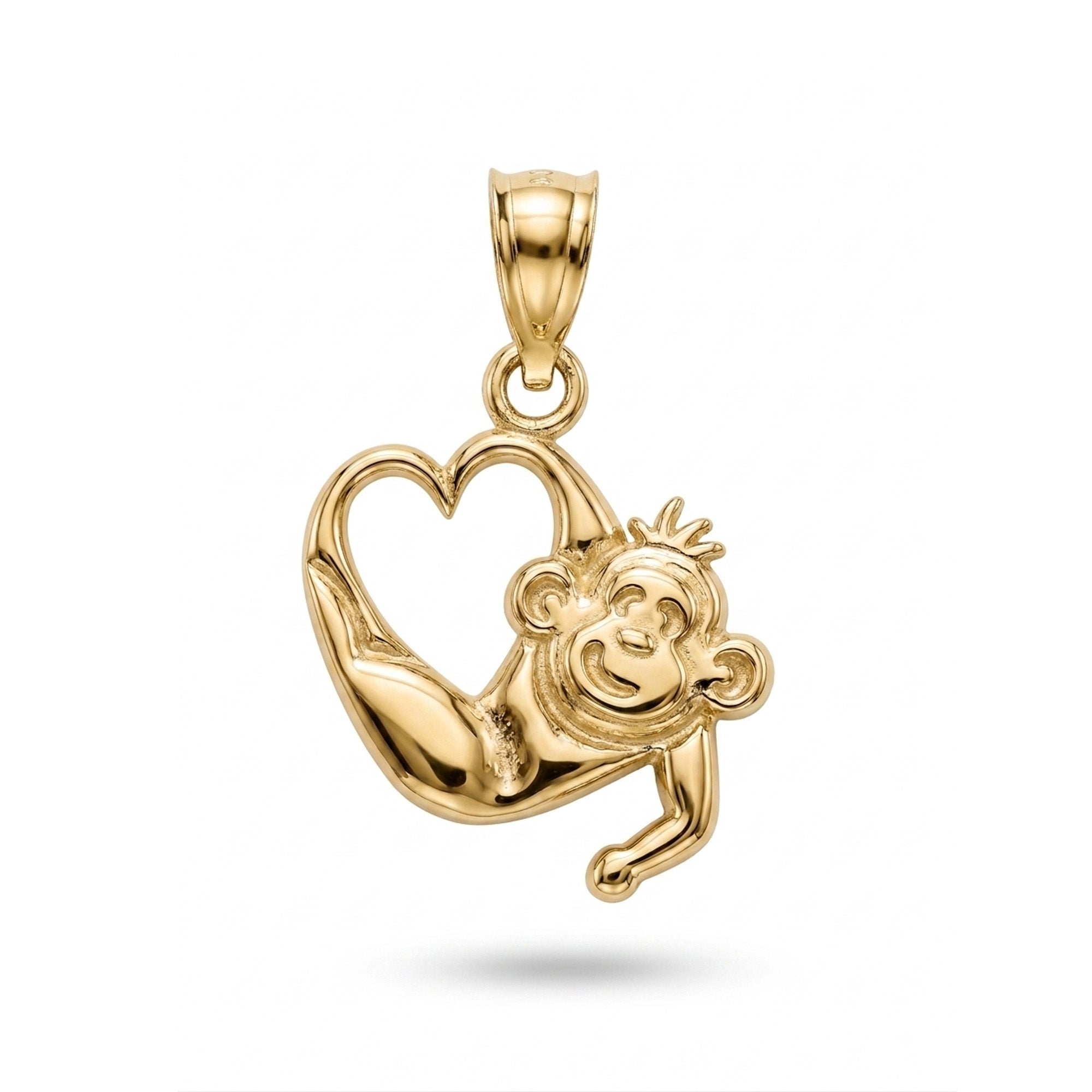 A polished yellow gold pendant featuring a monkey climbing over a heart-shaped outline, shown on a clean white background with a soft drop shadow.