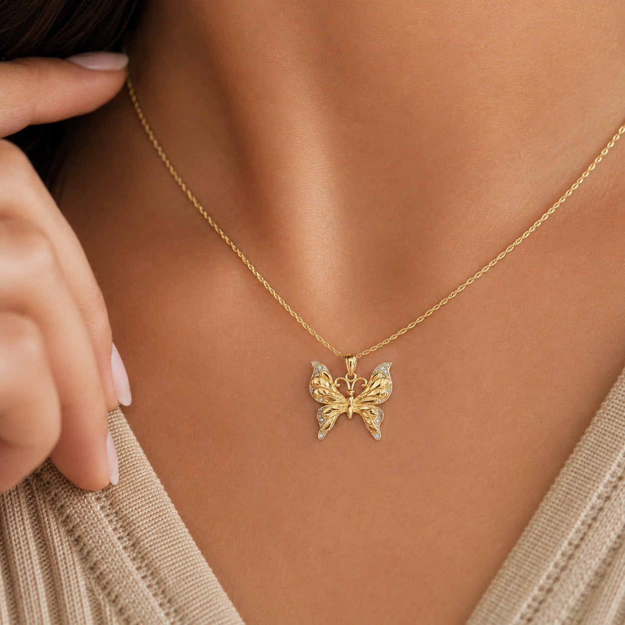 Gold butterfly necklace on a person's neck with a blurred background