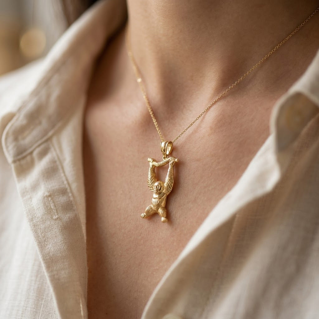 Gold necklace with a pendant worn by a person against a neutral background