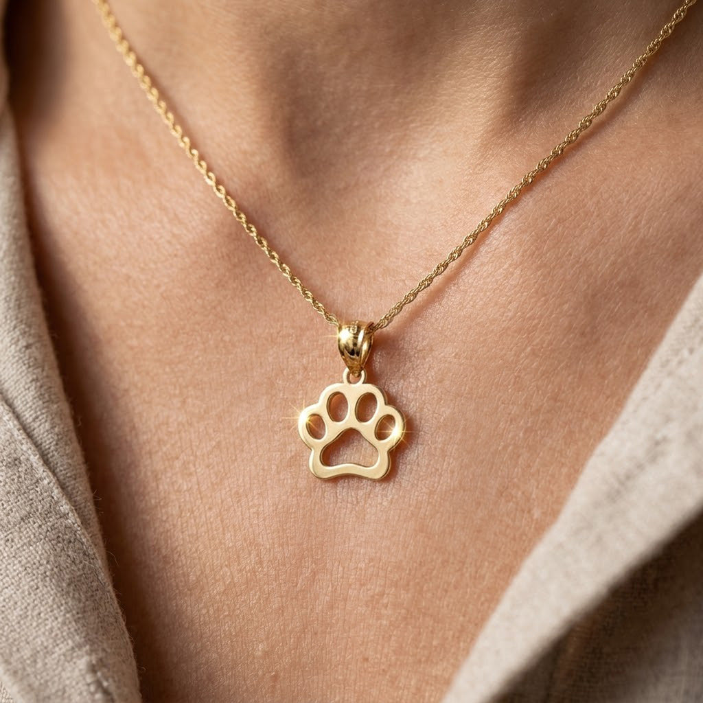 [group: large]Gold necklace with a paw print pendant on a person's neck