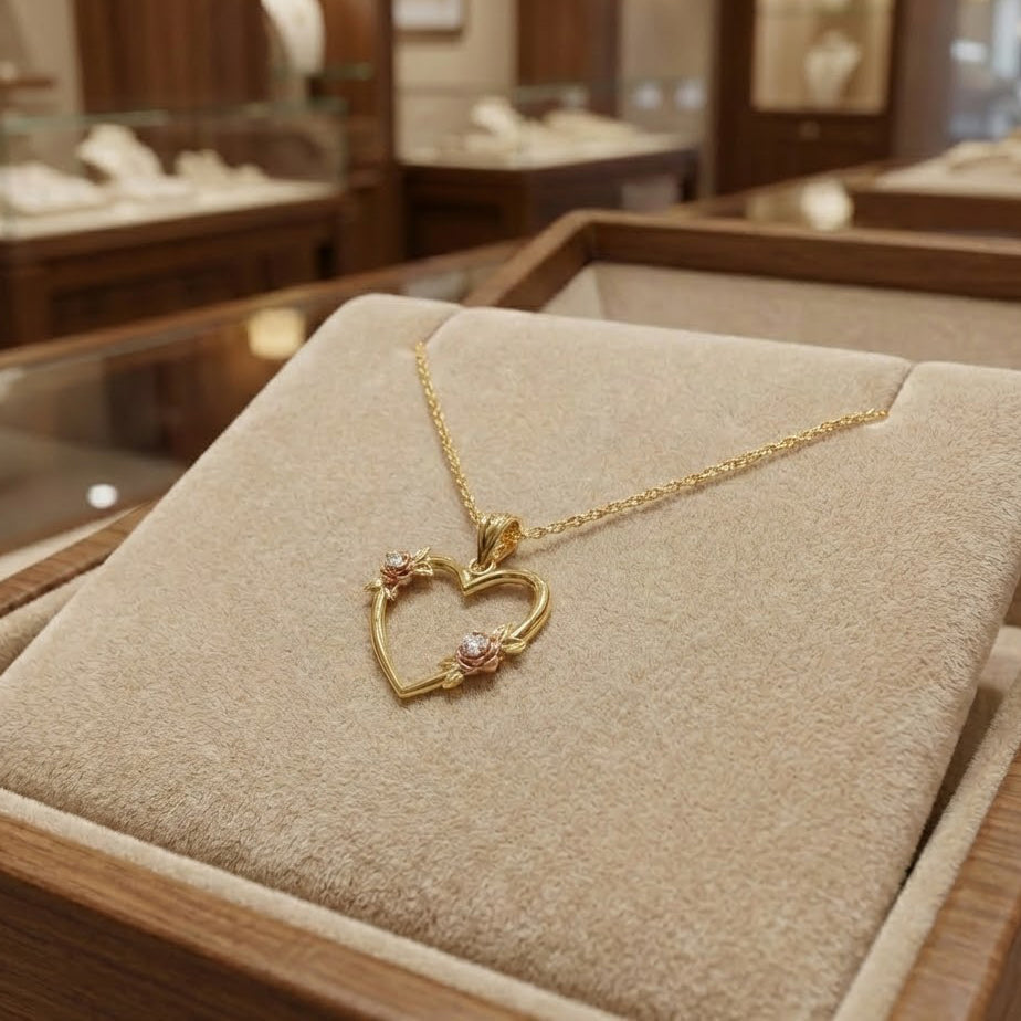 gold heart pendant with floral design in luxury display case 