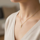 Gold Rose Pendant worn by female model on gold rope chain 