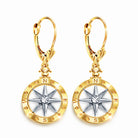 Gold and silver compass-shaped earrings on a white background