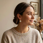 Woman wearing a beige sweater with a neutral background