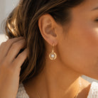 Gold Compass Earring on female model 