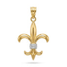 A polished yellow gold fleur-de-lis pendant with a textured silver band at the center and a small clear gemstone in the bail, shown on a white background.