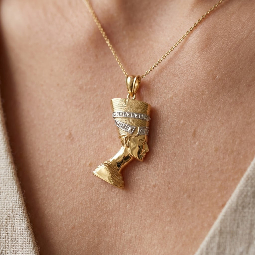 [group:10k-gold] Gold necklace with a pendant shaped like a face on a person's neck.