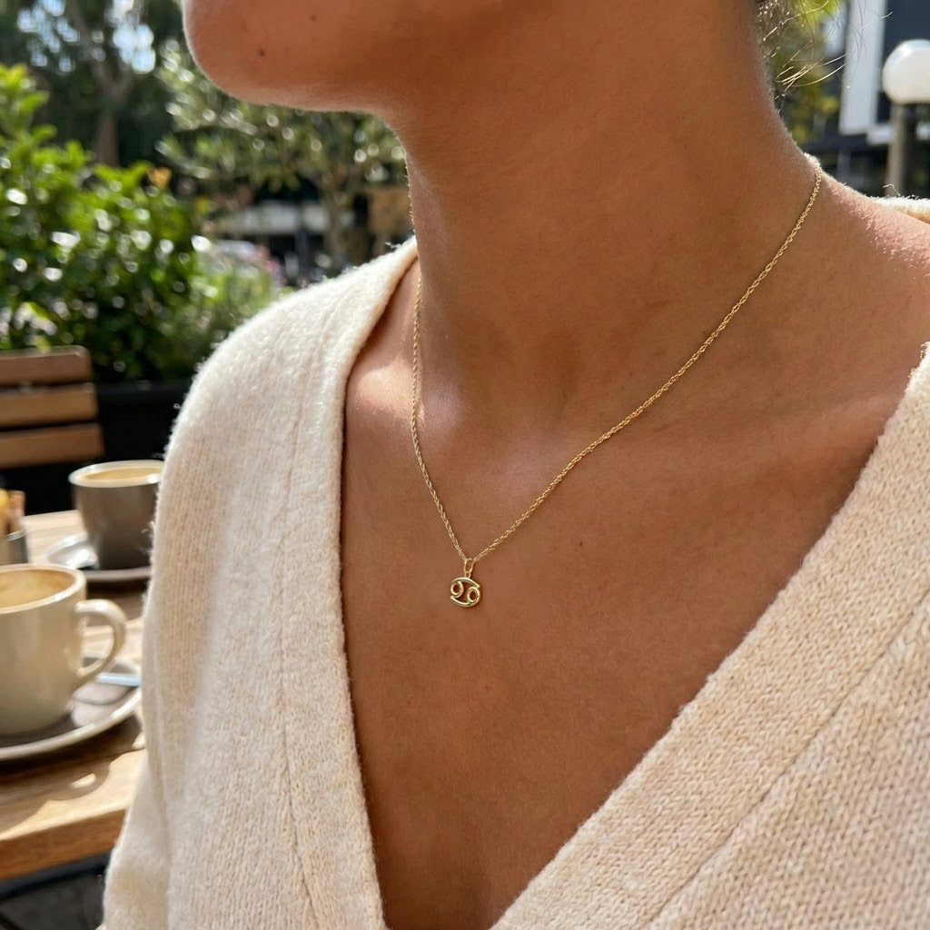 [group: cancer] Gold cancer zodiac pendant worn by female model with gold rope chain 