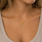 [group: small]A close-up of a model wearing a delicate gold chain necklace with a small, detailed octopus-shaped pendant.