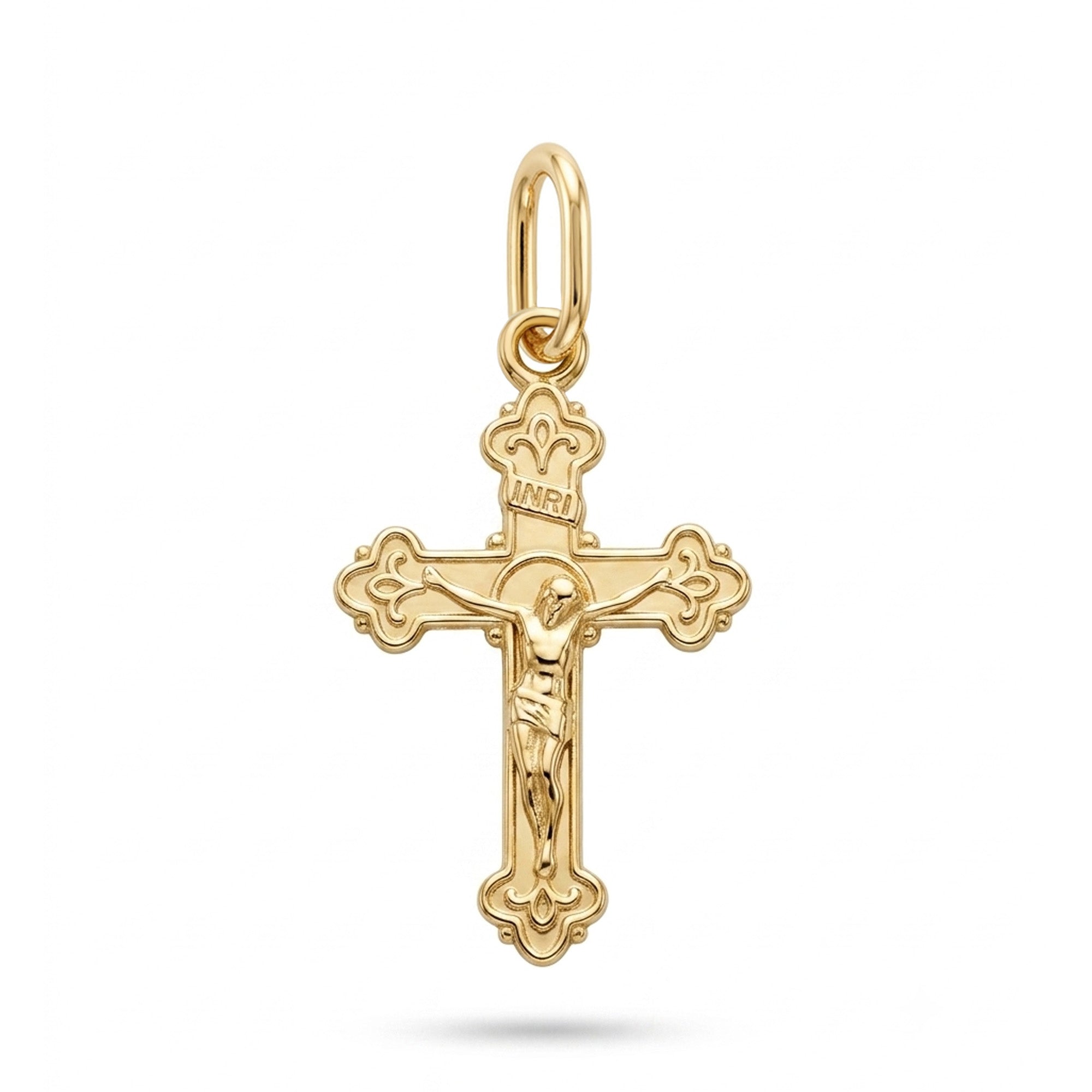 A polished yellow gold crucifix pendant featuring a detailed figure of Jesus Christ on the cross, with ornate decorative ends and an INRI inscription, shown on a clean white background.