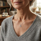 [group: silver] Woman wearing a necklace with a heart pendant in a cozy indoor setting