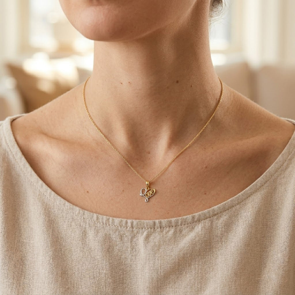 Necklace with a heart pendant worn by a person in a beige top.