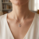 Necklace with 'LOVE' pendant worn by a person in a neutral setting